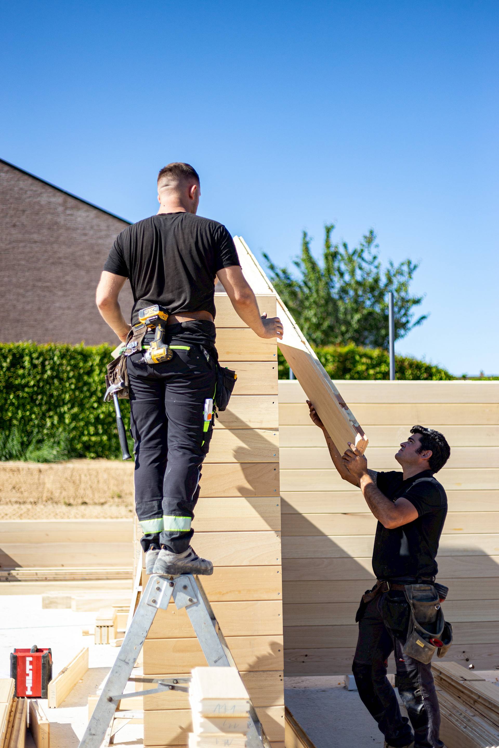 Massieve houten wanden worden geplaatst op de werf